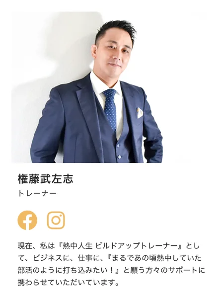 リカレント・ビジネス・カレッジの紹介ページにあるトレーナー紹介。スーツ姿の権藤武左志の写真の下に、トレーナー、熱中人生ビルドアップトレーナーとして、まるであの頃熱中していた部活のように打ち込みたいと願う方々のサポートに携わらせていただいていますと書かれている